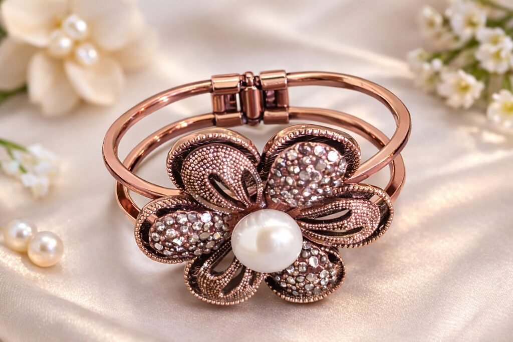 Rose-gold tone bracelet with butterfly/flower motif and pearl centre